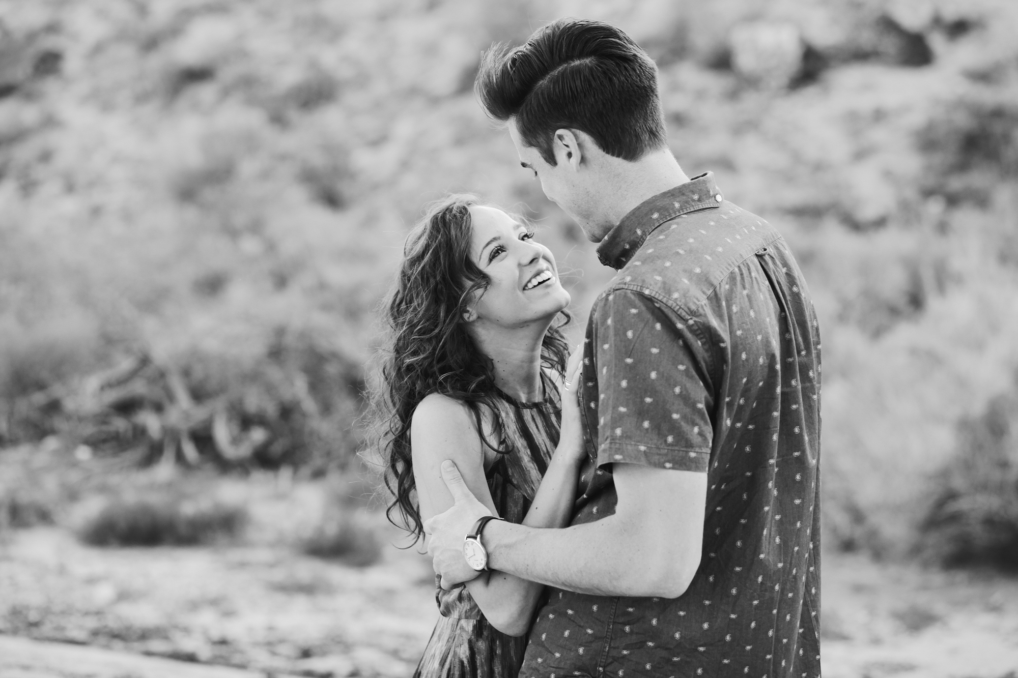 Jordan smiling and looking up at Riley at their desert shoot. 