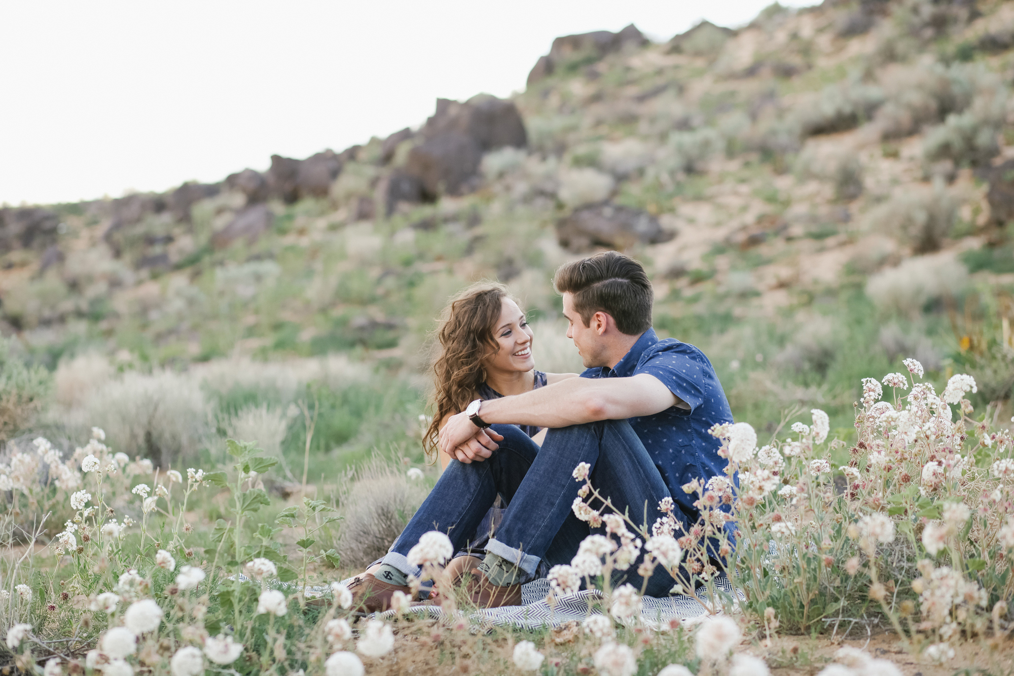 Jordan and Riley sitting on a blanket in the desert. 