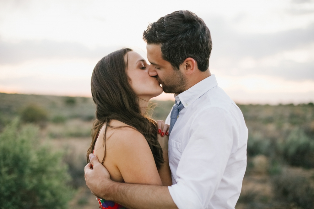 A lovely kiss photo out in the middle of the desert.