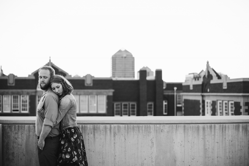 A black and white photo of the couple on a city rooftop. 