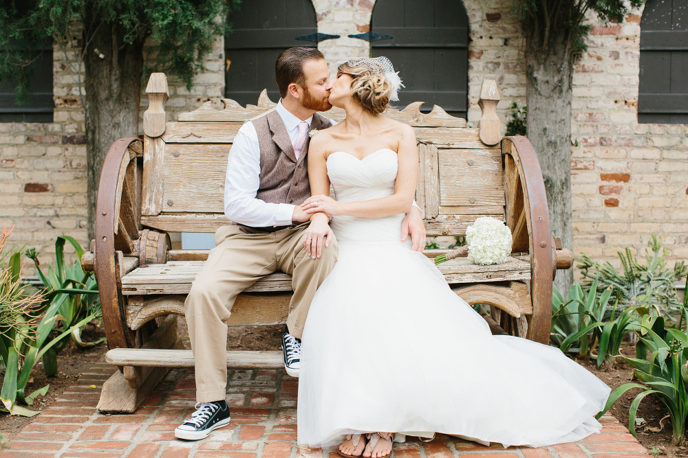 The couple kissed on an old wooden bench. 