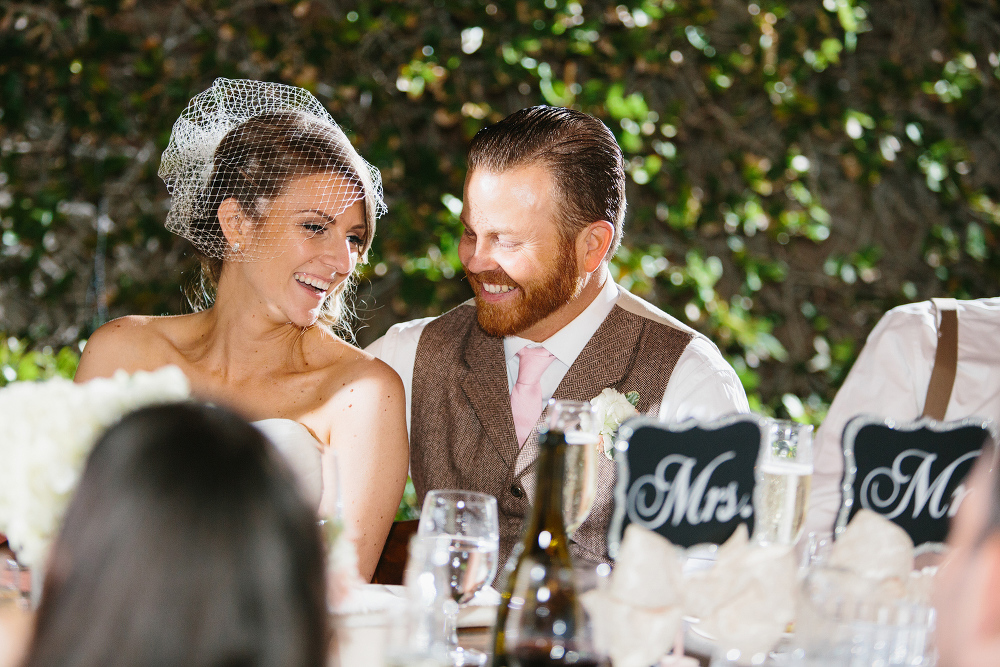 This is a photo of the bride and groom laughing during the reception. 