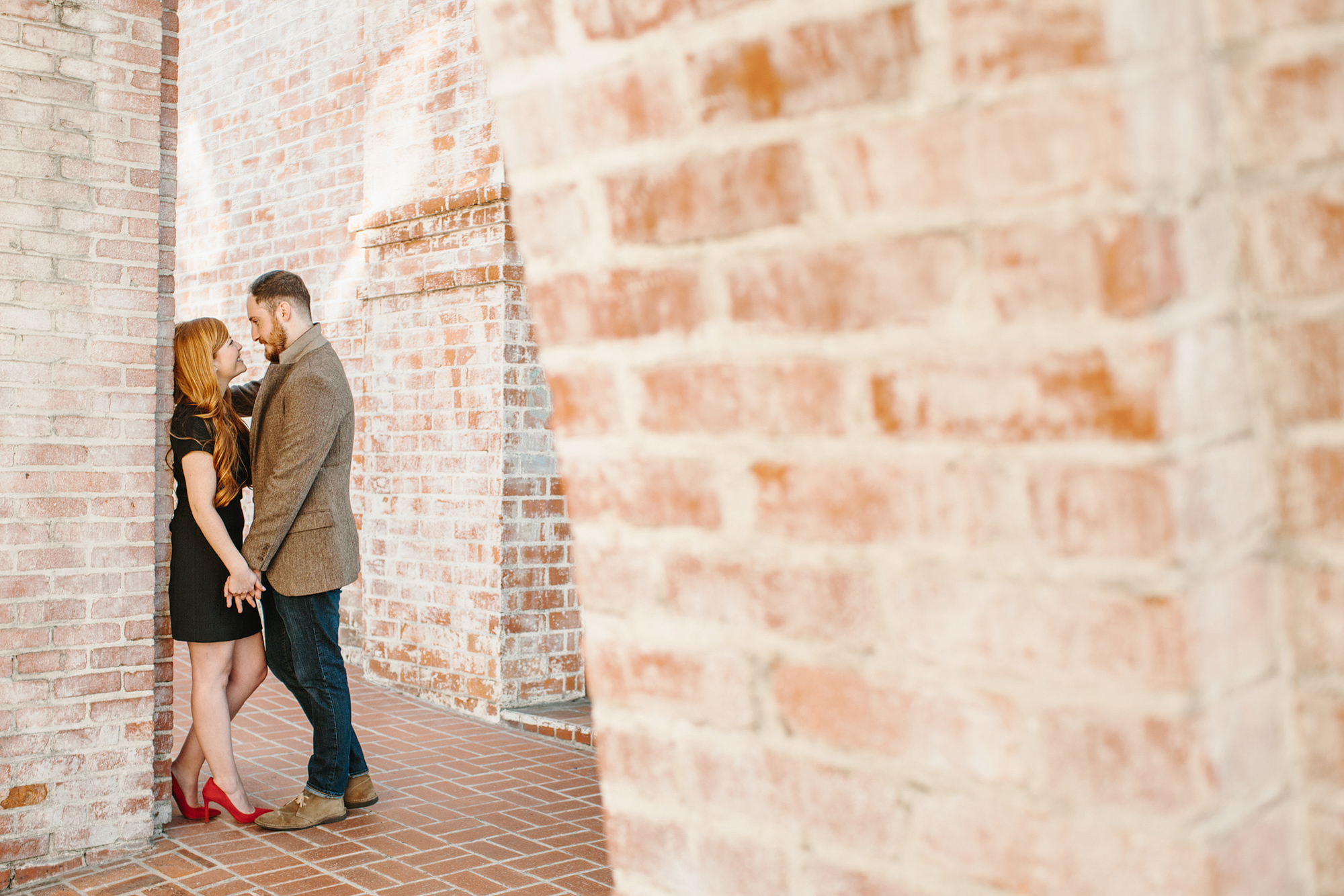 Here is a photo of Carrie and Justin looking at each other in a brick archway. 