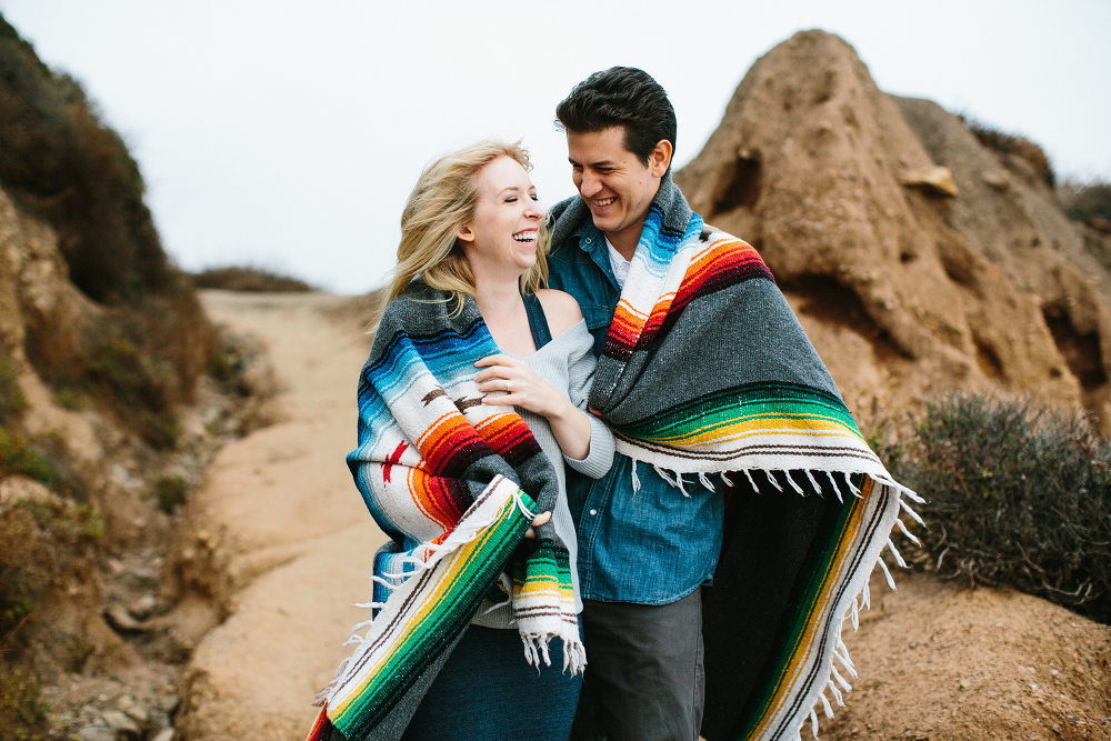 Here is a photo of the couple laughing at the beach. 