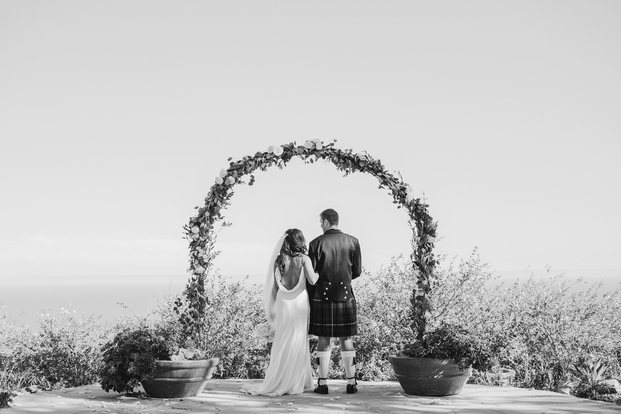 A black and white photo of the bride and groom in the ceremony space. 