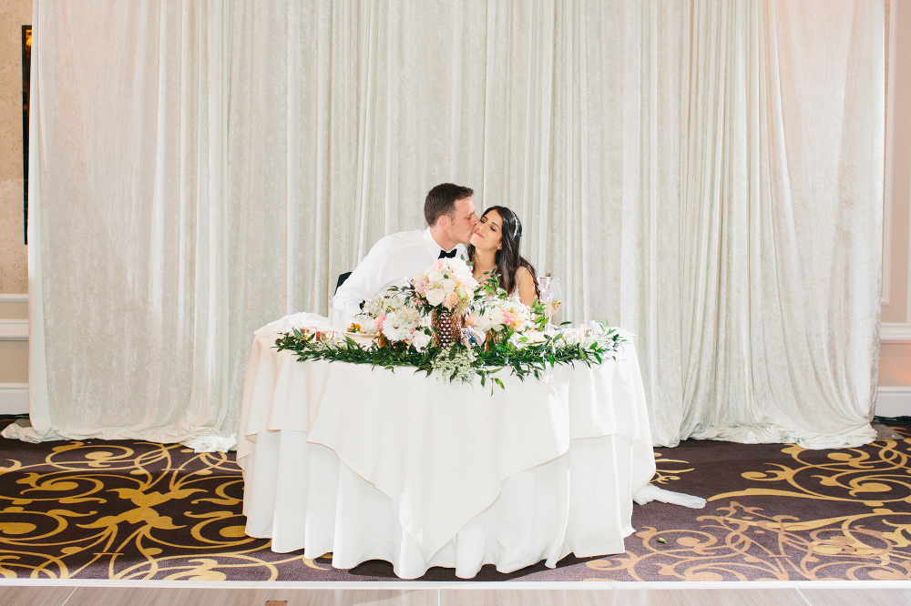 A sweet kiss between the bride and groom during dinner. 