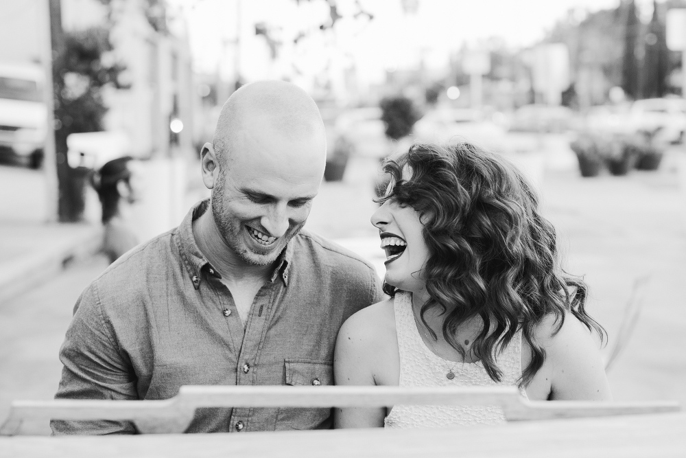 A black and white photo of the couple laughing. 