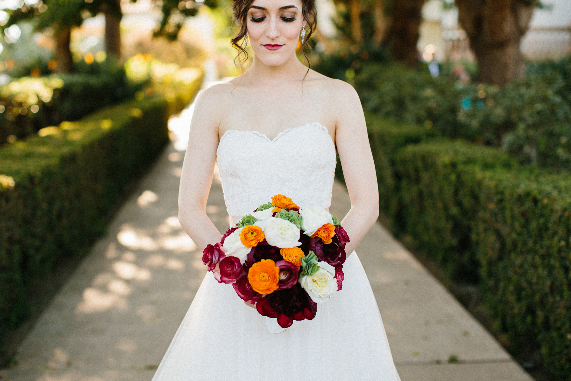 Laura holding her red and orange bridal bouquet. 