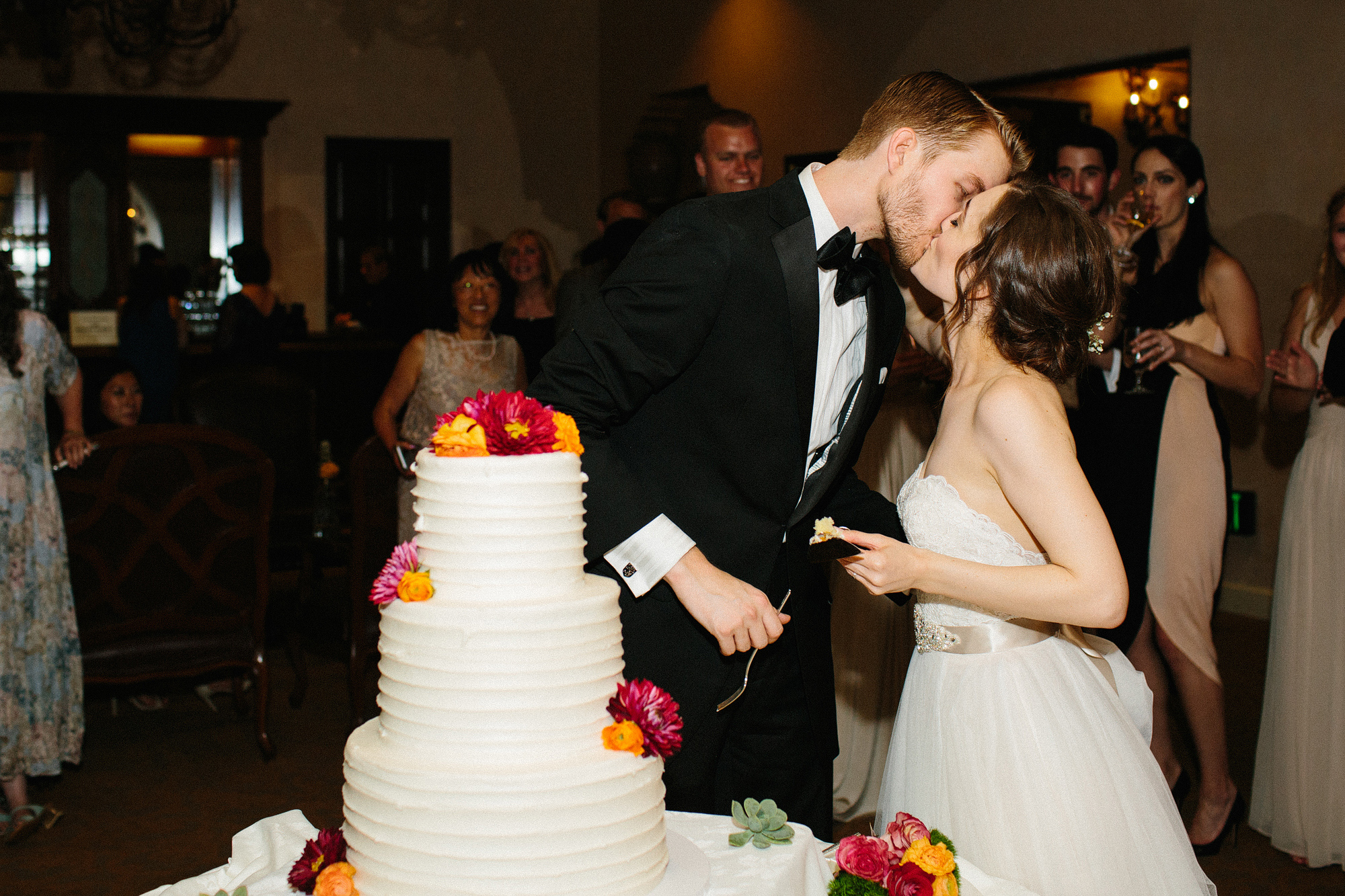 Laura and Karl kissing during cake cutting. 