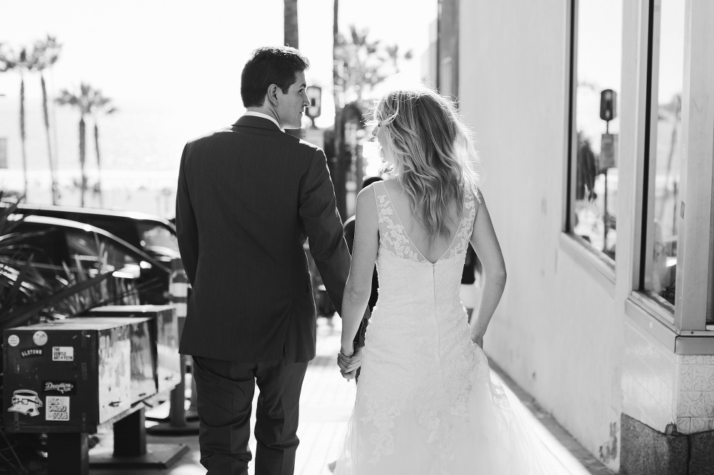 The bride and groom walking to the beach. 