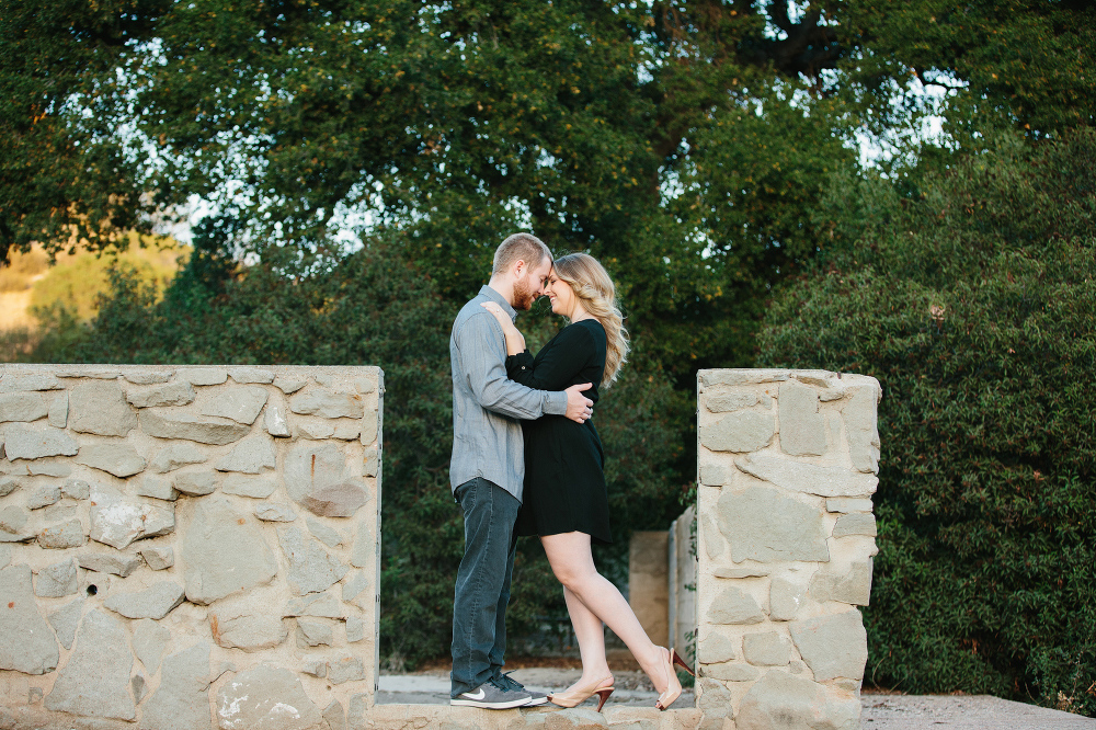 The couple standing on a brick structure. 