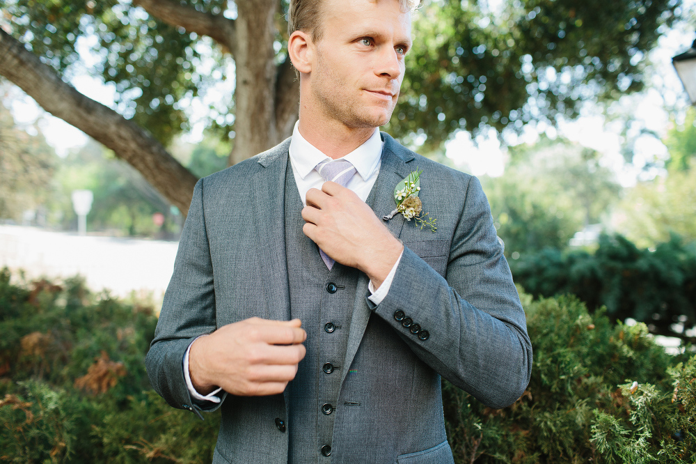 The groom adjusting his tie. 