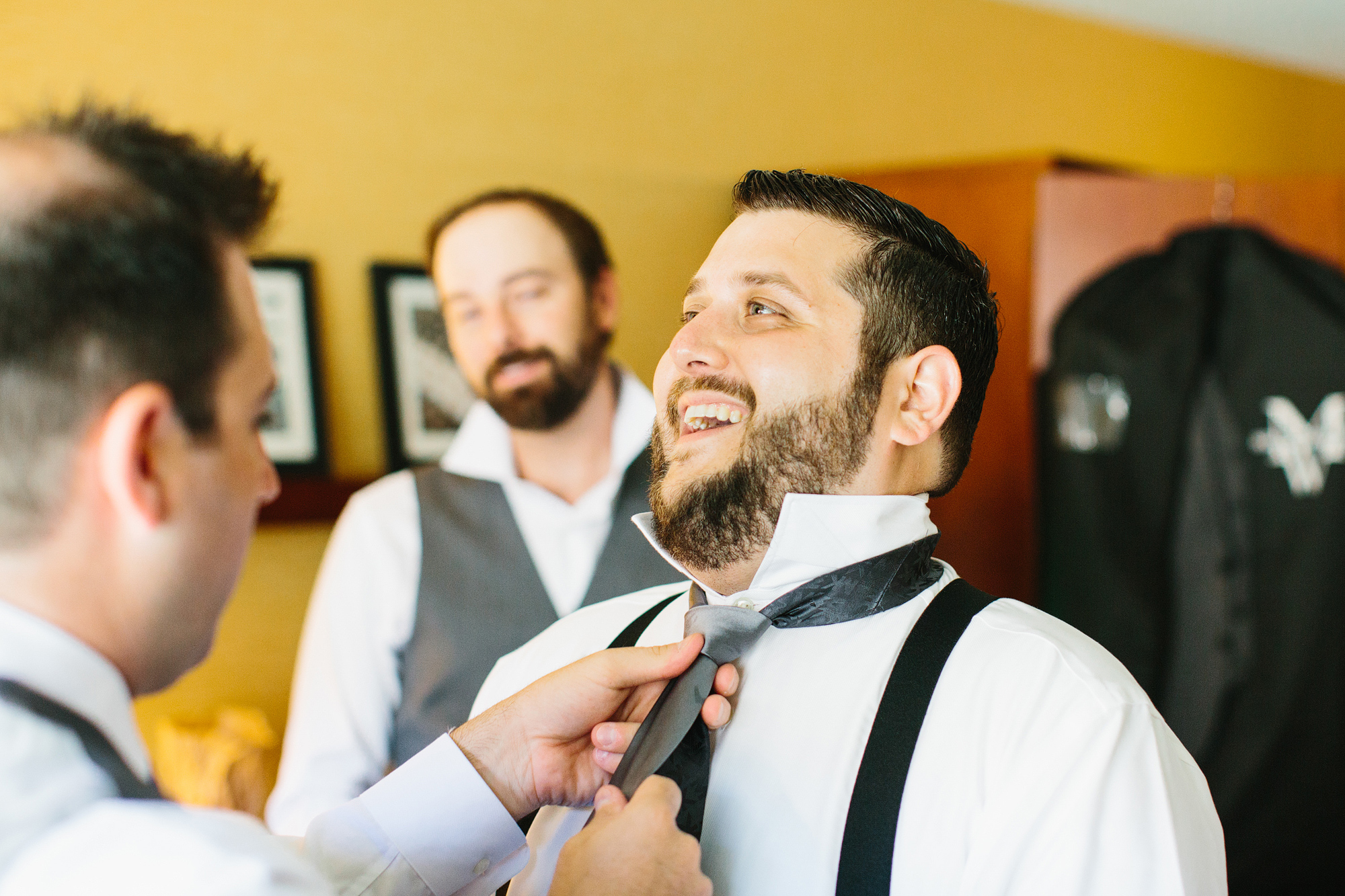 The groom putting his tie on. 