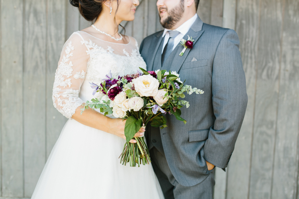 The bride and groom on the side of the barn. 