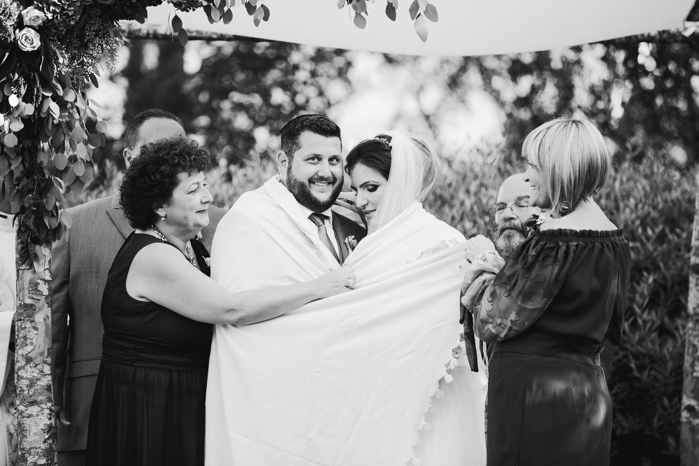 The couple wrapped in a prayer shawl. 