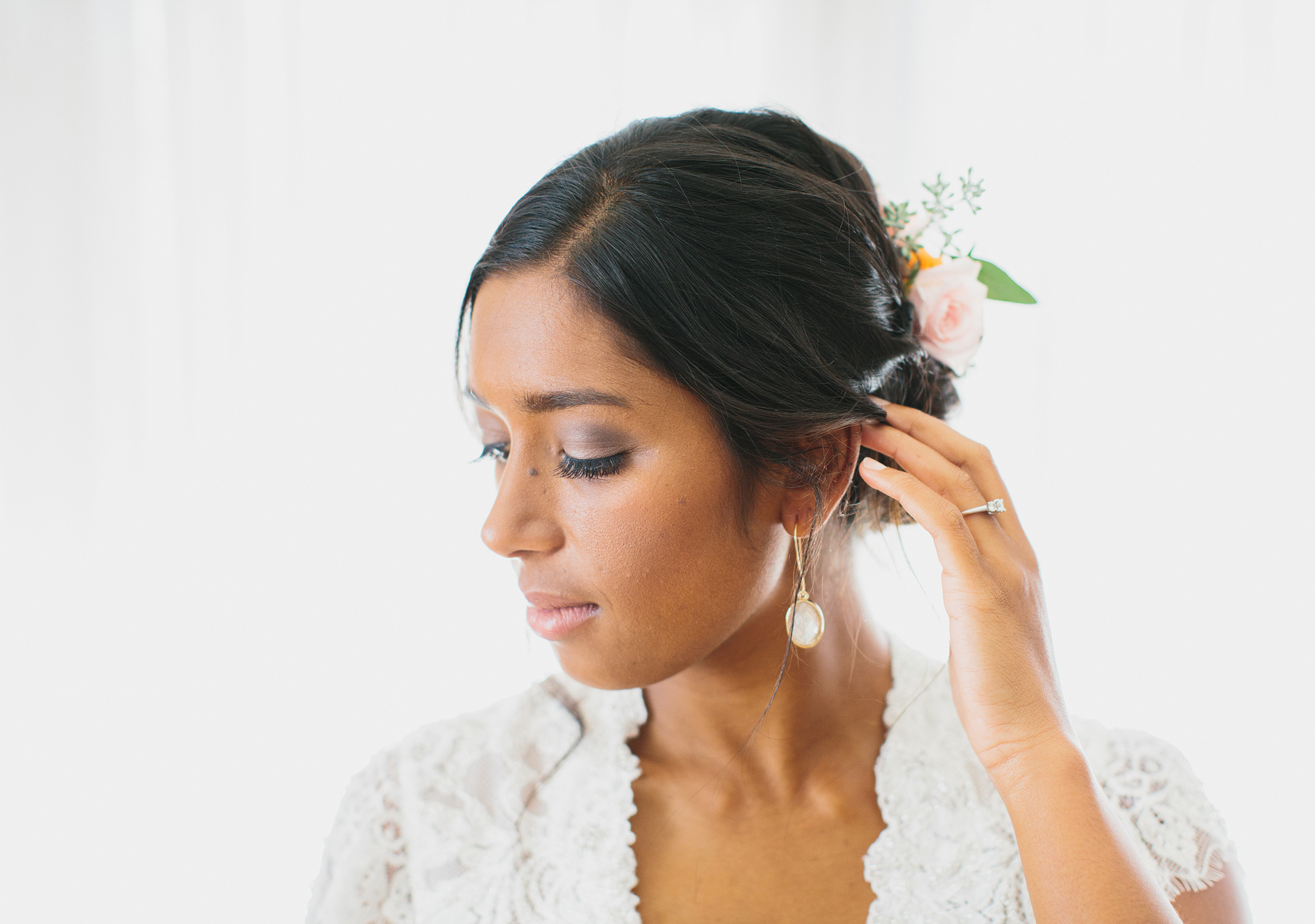 A photo of the bride's makeup and earrings. 
