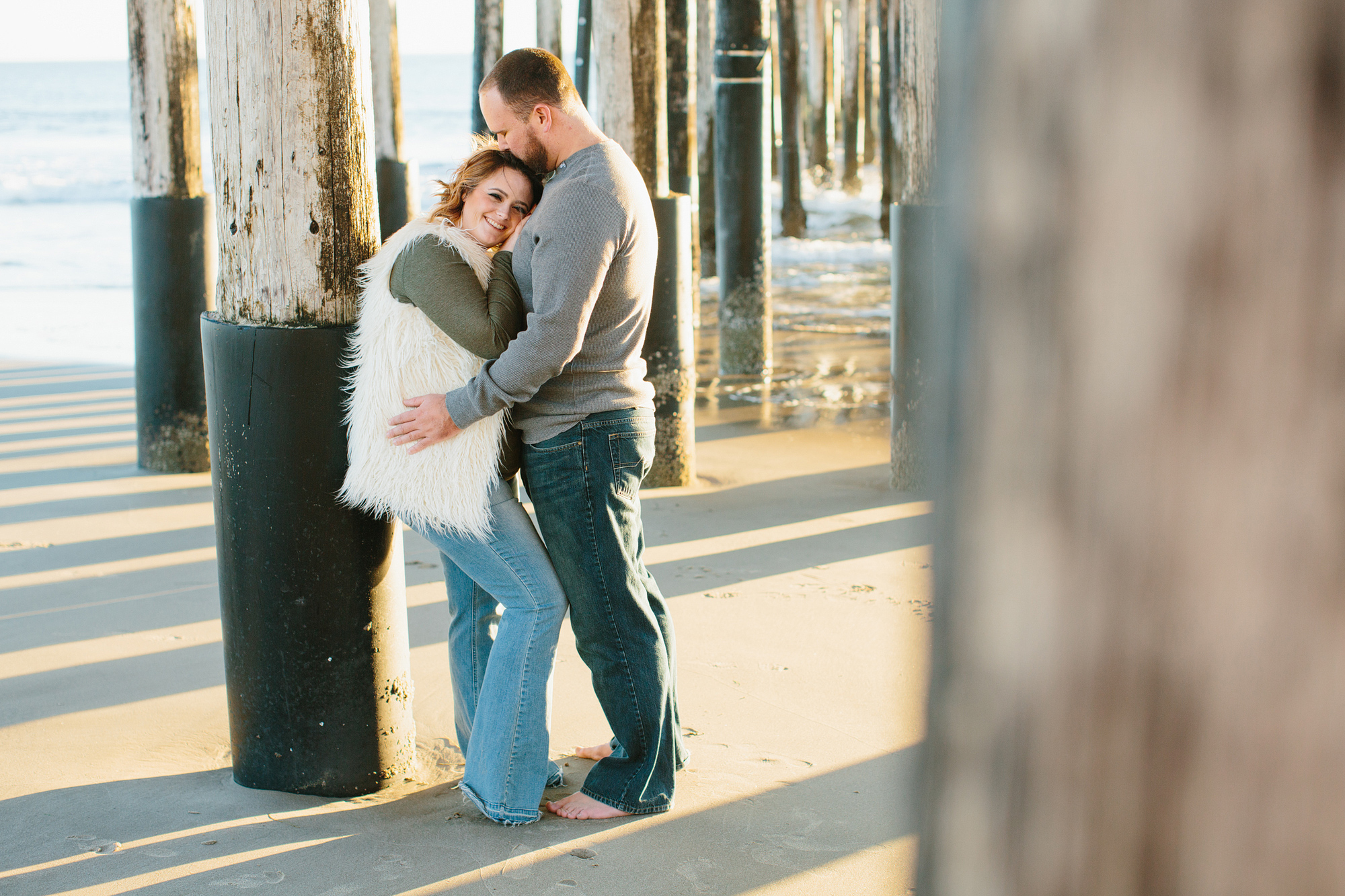 A sweet photo of the couple leaning against the pier. 