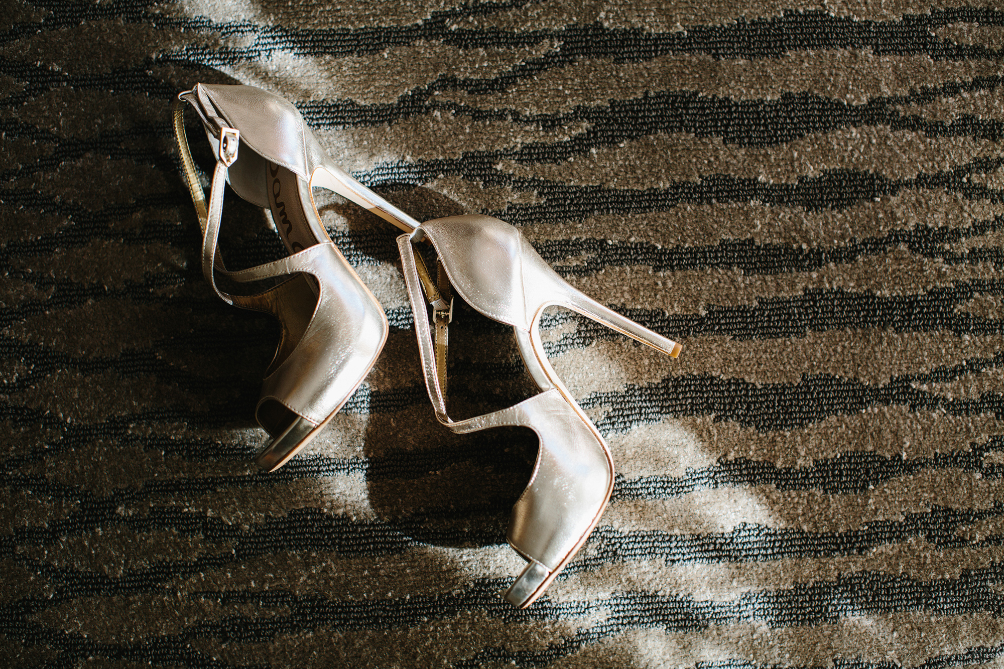 Bailey's gold heels in the sunlight in her hotel room. 