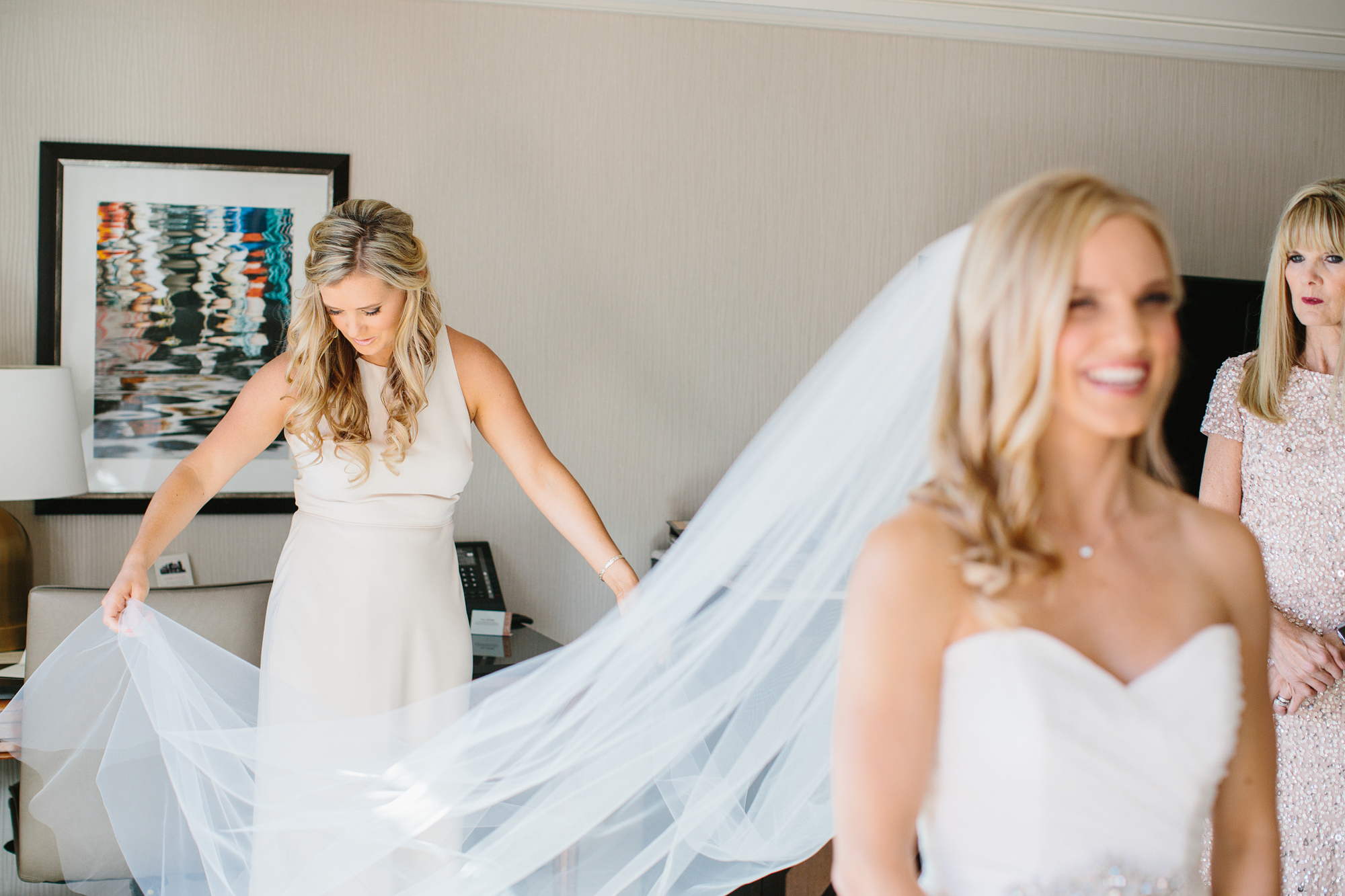 A photo of Bailey's bridesmaid putting on her veil. 
