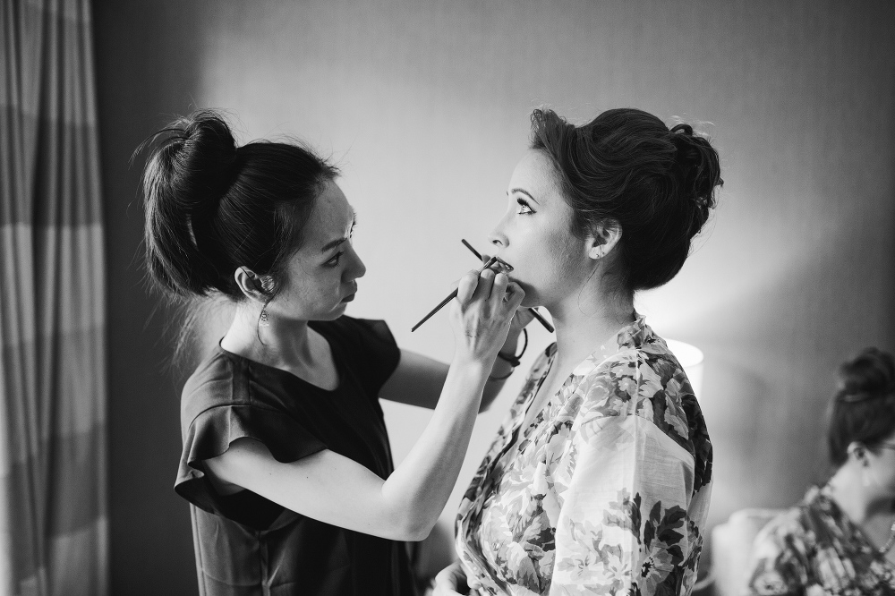 A beautiful black and white photo of the bride getting her makeup done. 