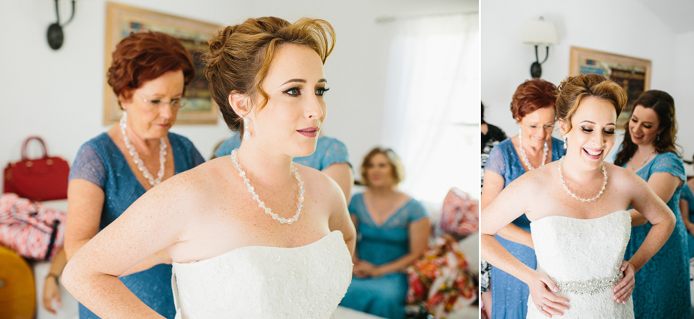 The mother of the bride helping her daughter get dressed. 