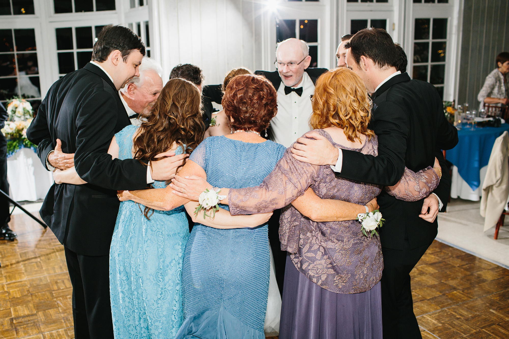 The bride and groom's immediate families dancing together. 