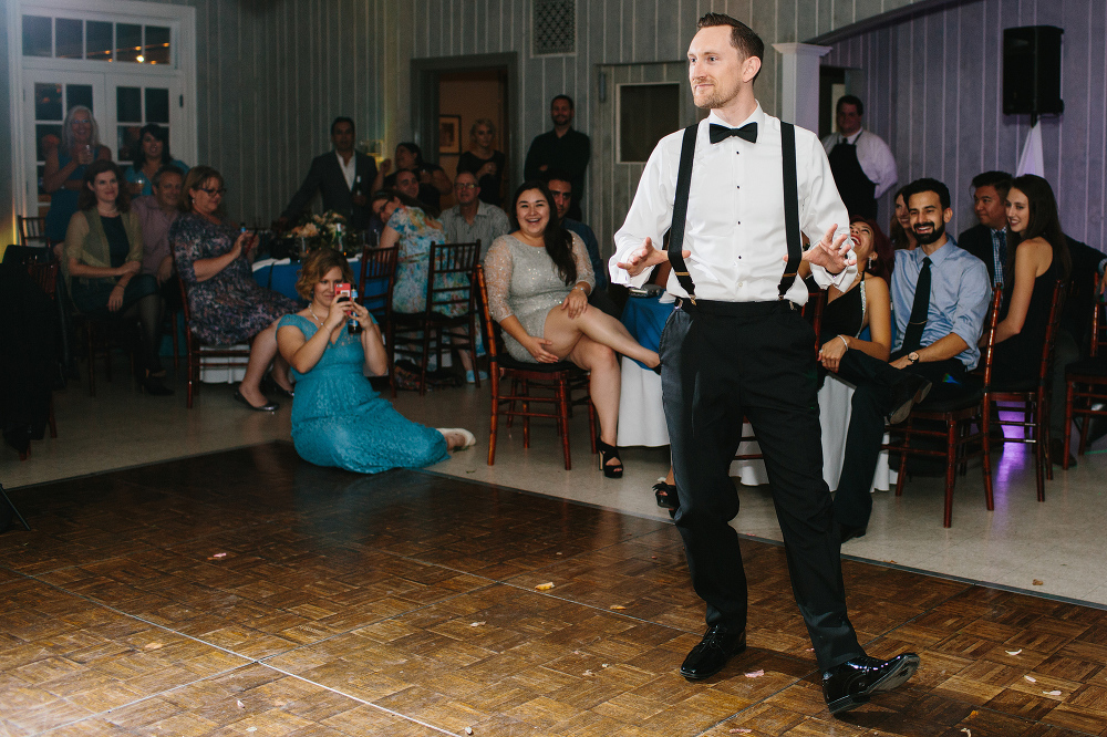 The groom dancing over to the bride during the garter toss. 