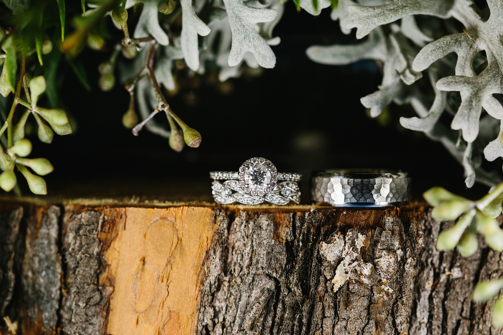 The wedding rings on a piece of wood. 