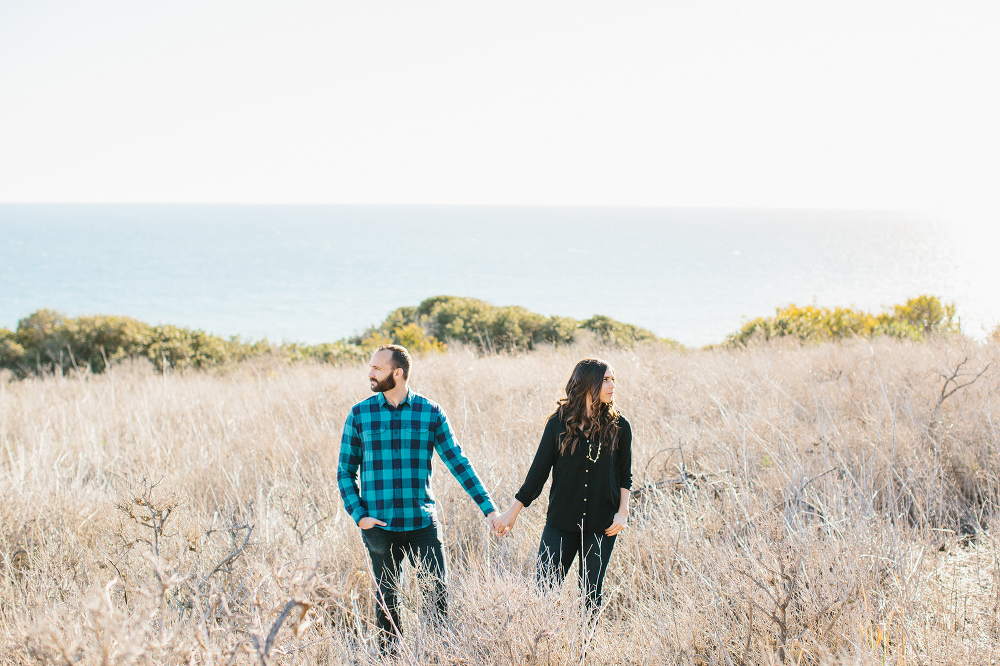 The couple looking away in the fields at the beach. 