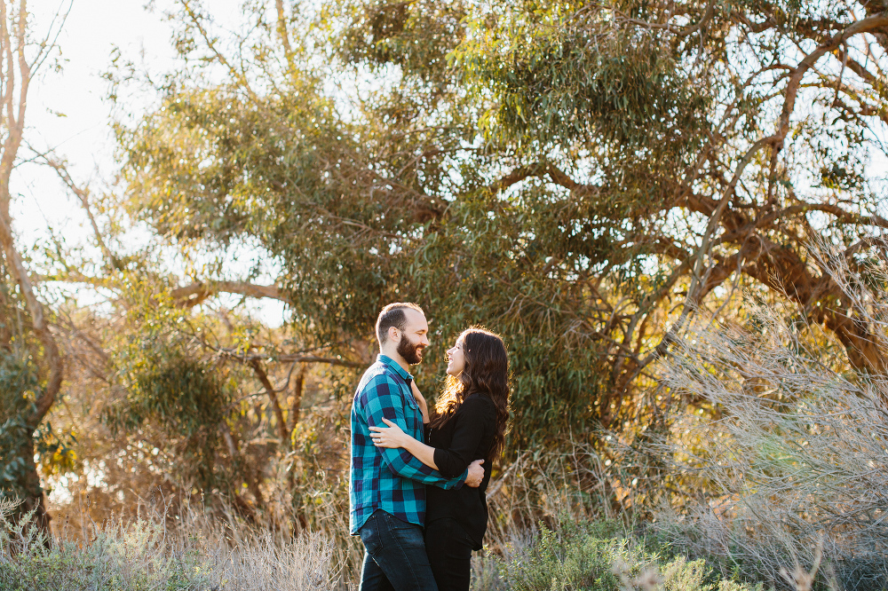 The couple laughing together in the fields. 