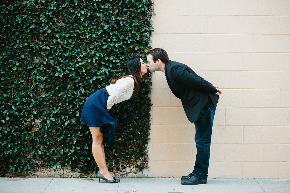 Janice and Mike kissing in the middle of two walls. 