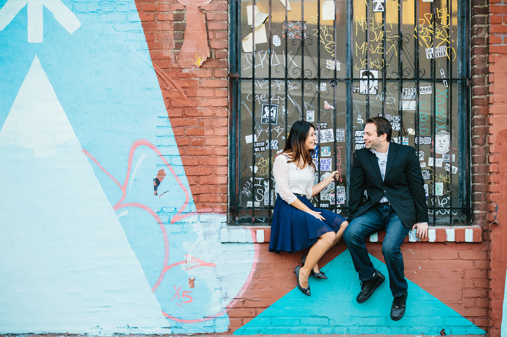 The couple sitting on a brick wall. 