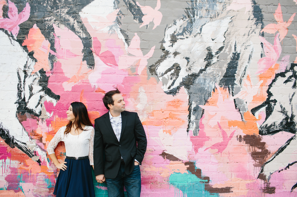 Janice and Mike in front of a bright mural. 