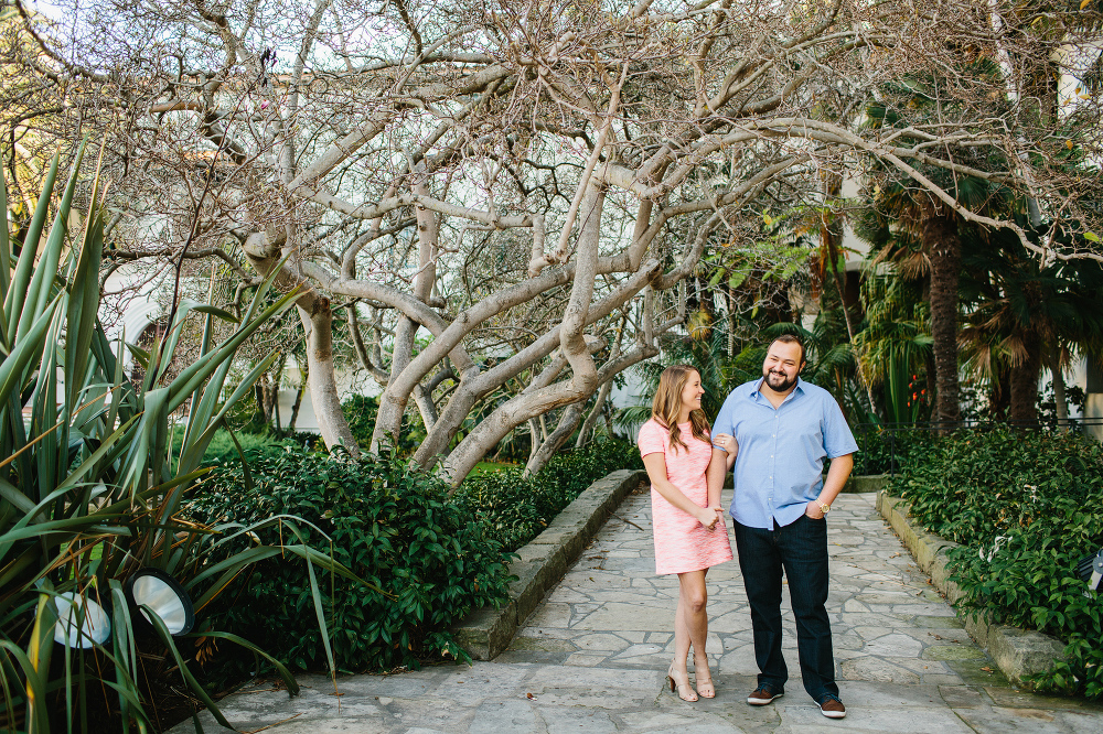 The couple standing under a large tree. 