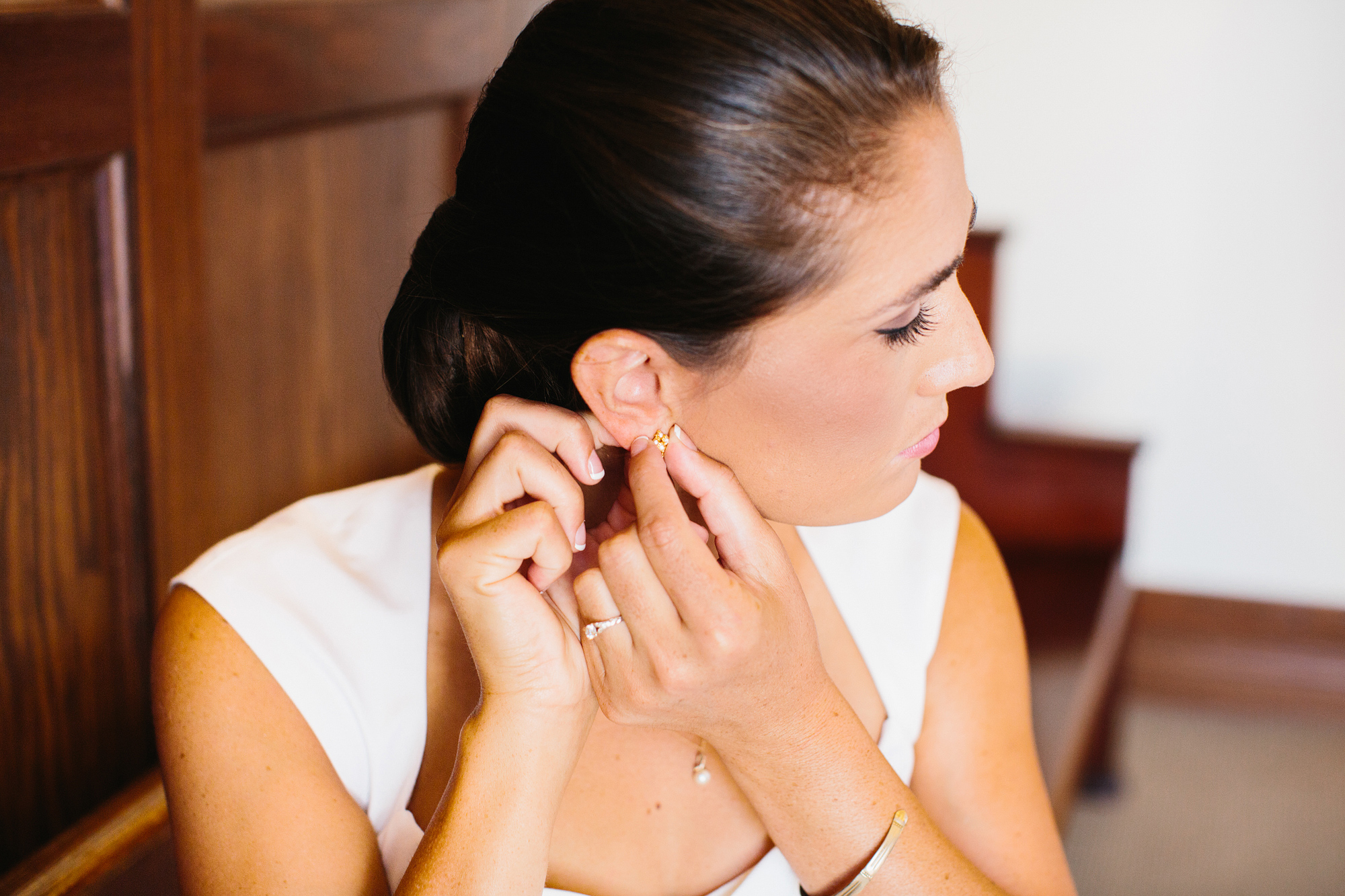 The bride putting on her earrings. 