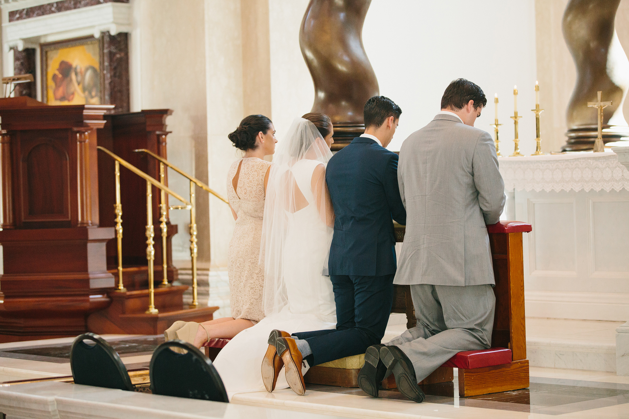 The couple kneeling during the ceremony. 