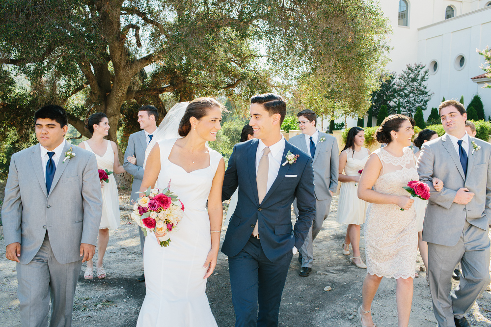 The bride and groom walking with their wedding party. 