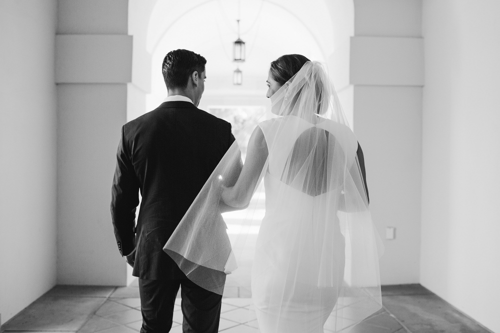 The bride and groom walking in the halls at the college. 