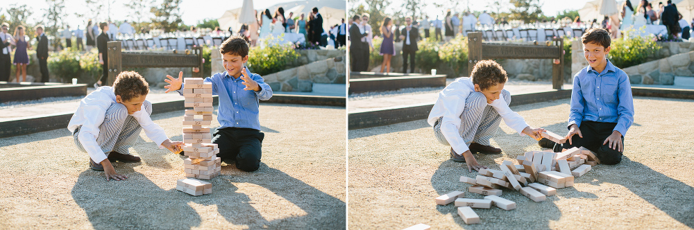 Two little kids playing a large Jenga. 