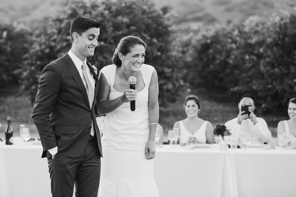 The bride and groom laughing during their toast. 