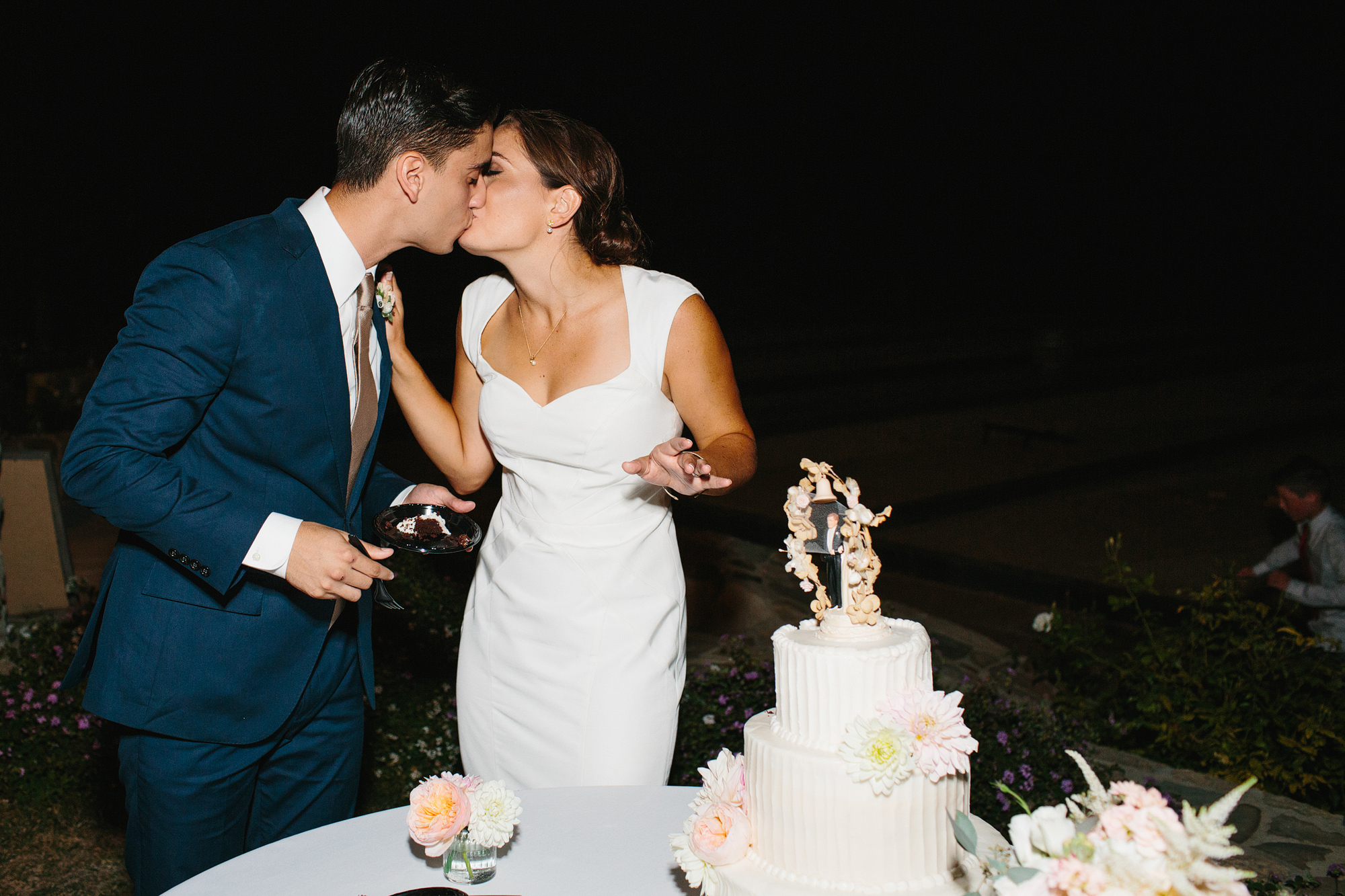 The couple sharing a kiss after cake cutting. 