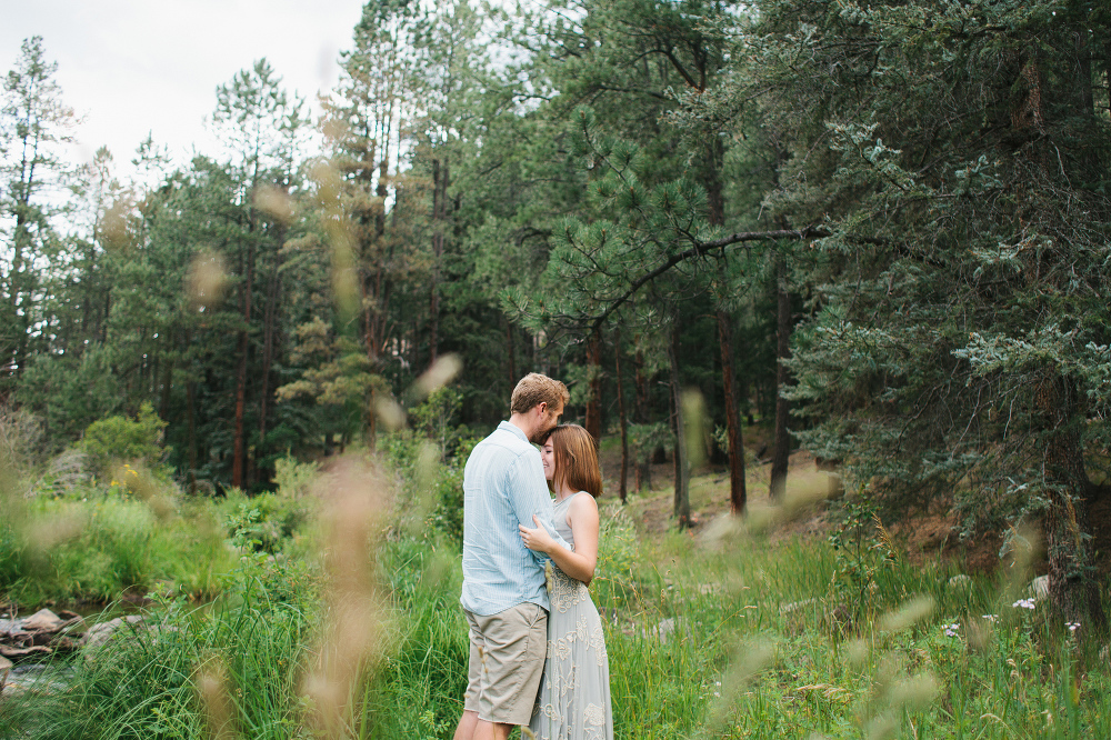 The couple was surrounded by trees and tall grass. 
