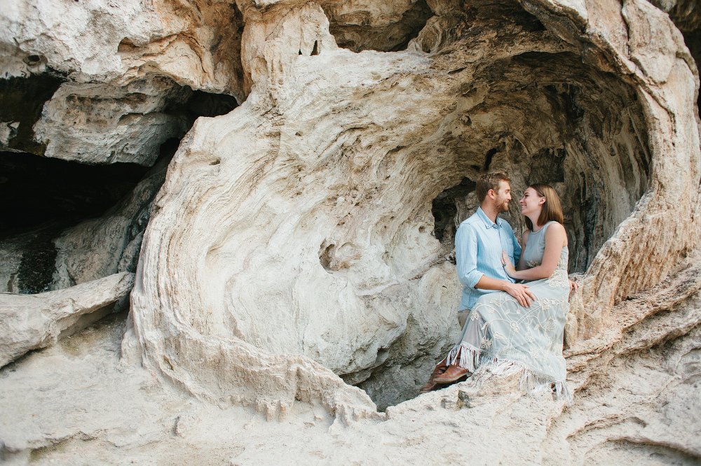The couple sitting in a rock cove. 