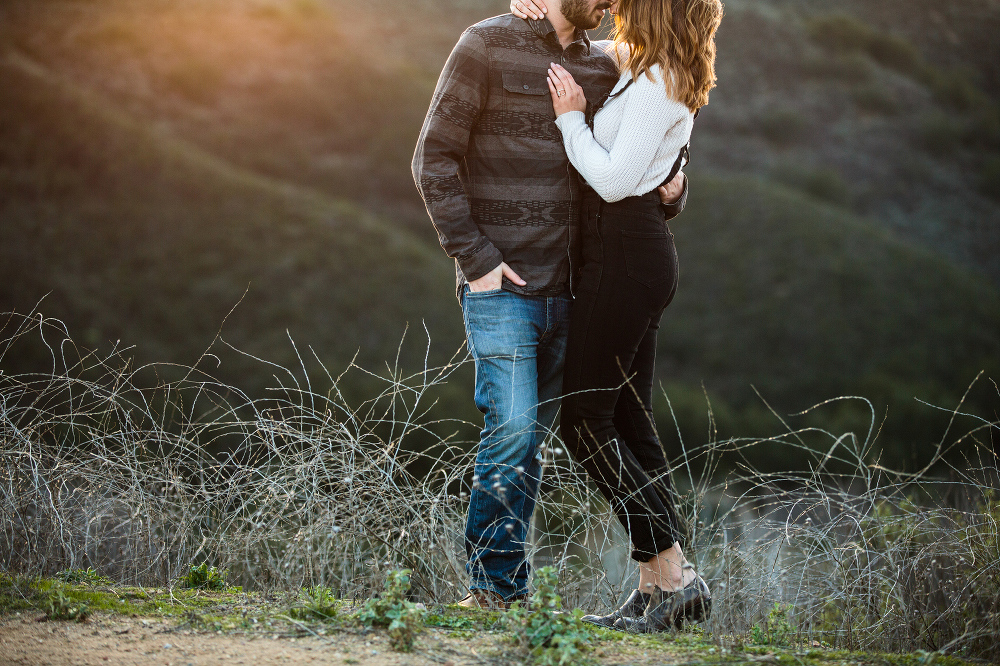 Kailie and Michael standing in the fields on the hill. 