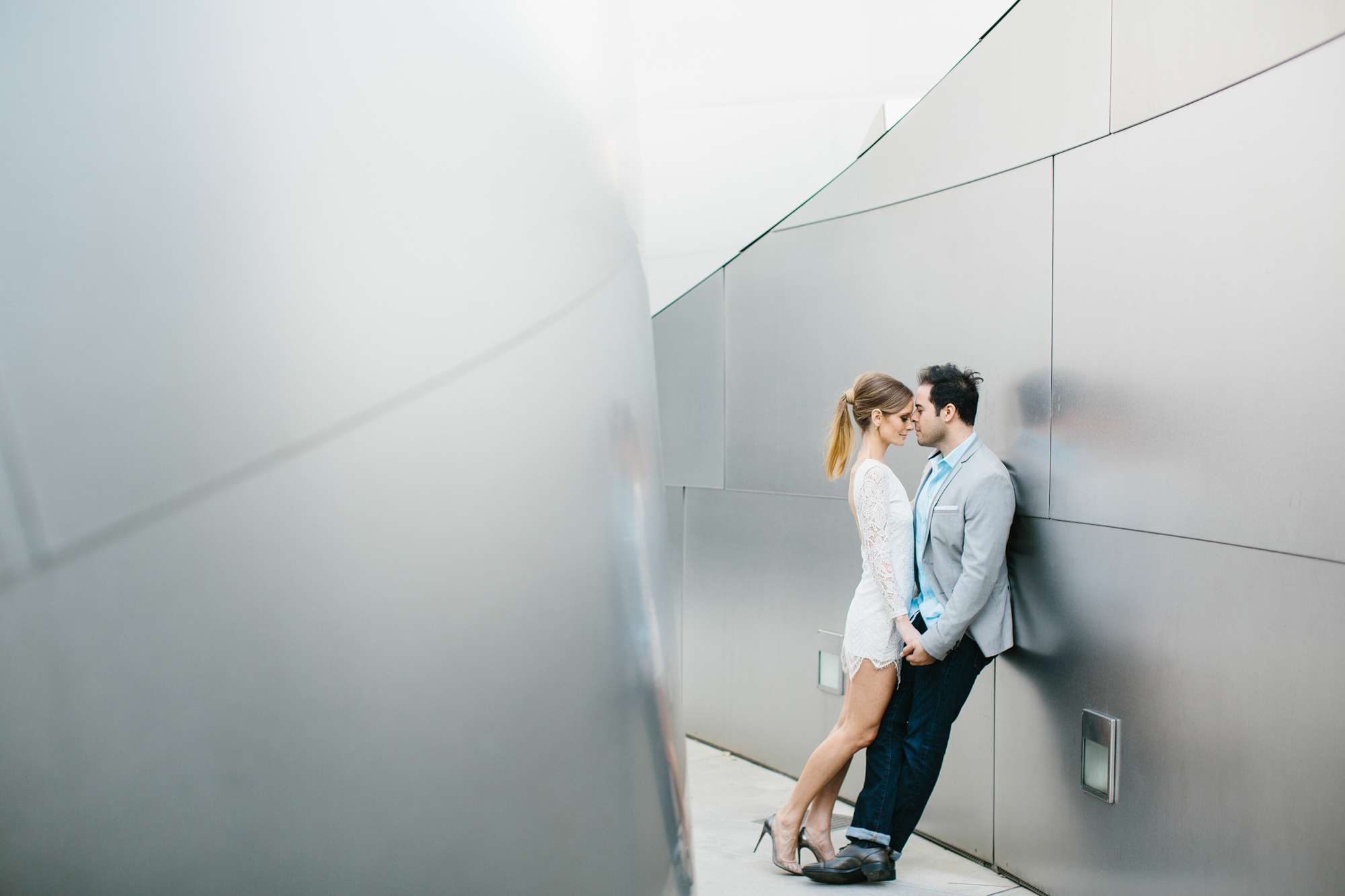 Ashley and Luis leaning on a wall. 