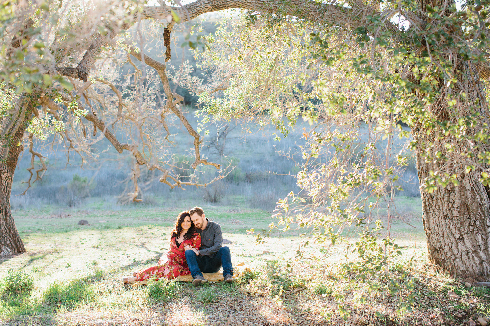 The couple sitting on a blanket. 