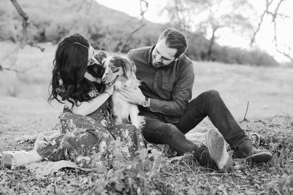 The couple playing with their dog. 