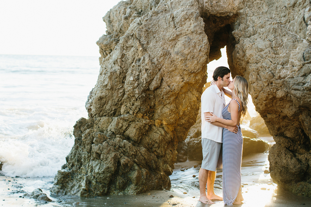 Megan and Travis by a large beach rock. 