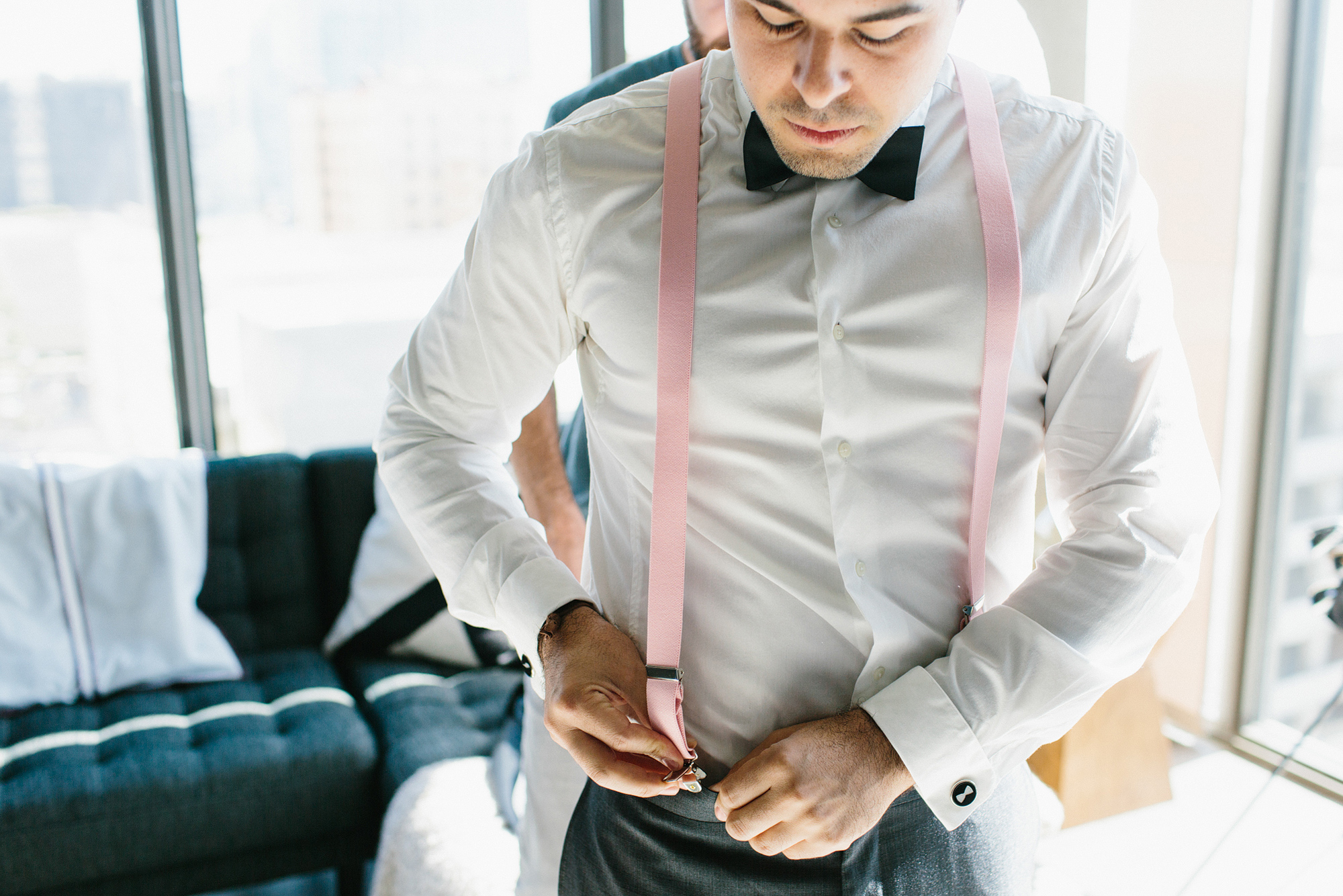 Luis putting on his suspenders. 