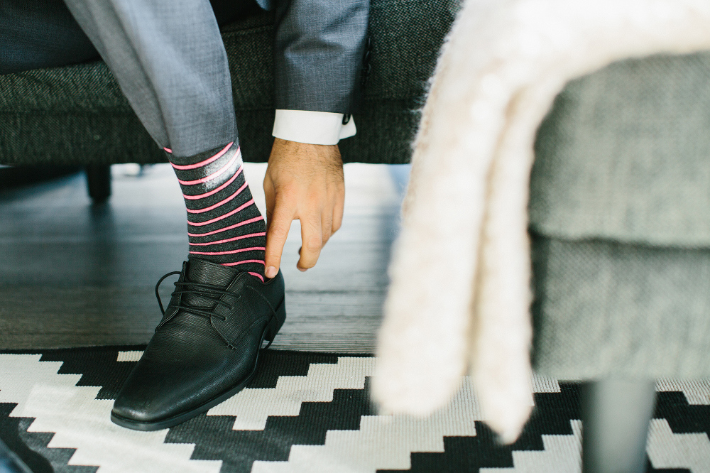 The groom putting on his shoes. 